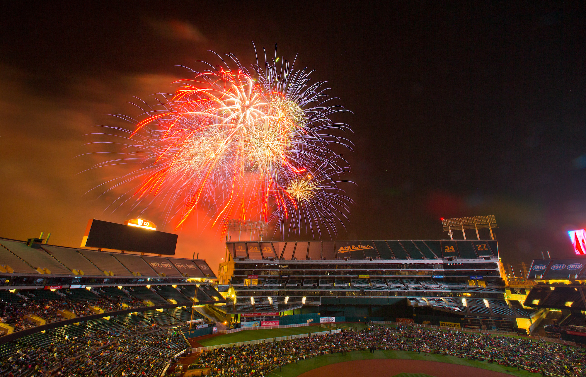 OAKLAND, CA - JUNE 19: Fans crowd onto the field for fireworks after a game between the Oakland Athletics and the Los Angeles Angels of Anaheim at O.co Coliseum on June 19, 2015 in Oakland, California. The Angels won 12-7. (Photo by Brian Bahr/Getty Images)