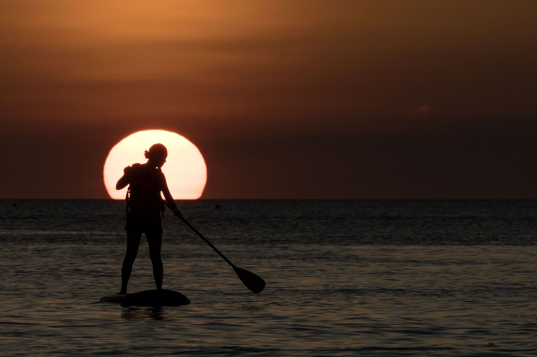 A tourist practices with a paddleboard during a sunset in Philippine's Boracay island on April 24, 2018, ahead of its closure. - Police with assault rifles patrolled entry points to Boracay island on April 24 just days before a six-month shutdown and clean-up of one of the Philippines' top tourist attractions. (Photo by NOEL CELIS / AFP) (Photo credit should read NOEL CELIS/AFP via Getty Images)