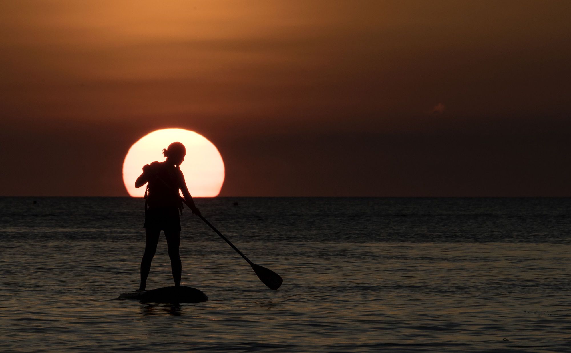 A tourist practices with a paddleboard during a sunset in Philippine's Boracay island on April 24, 2018, ahead of its closure. - Police with assault rifles patrolled entry points to Boracay island on April 24 just days before a six-month shutdown and clean-up of one of the Philippines' top tourist attractions. (Photo by NOEL CELIS / AFP) (Photo credit should read NOEL CELIS/AFP via Getty Images)