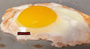 An egg, frying in a pan