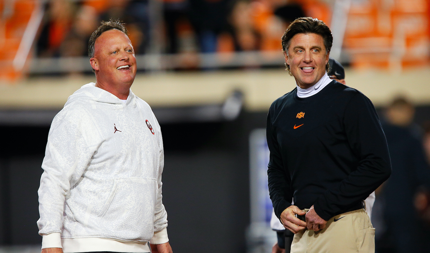 STILLWATER, OK - NOVEMBER 27: Offensive coordinator Cale Gundy of the Oklahoma Sooners greets his brother, head coach Mike Gundy of the Oklahoma State Cowboys, before their game at Boone Pickens Stadium on November 27, 2021 in Stillwater, Oklahoma. (Photo by Brian Bahr/Getty Images)