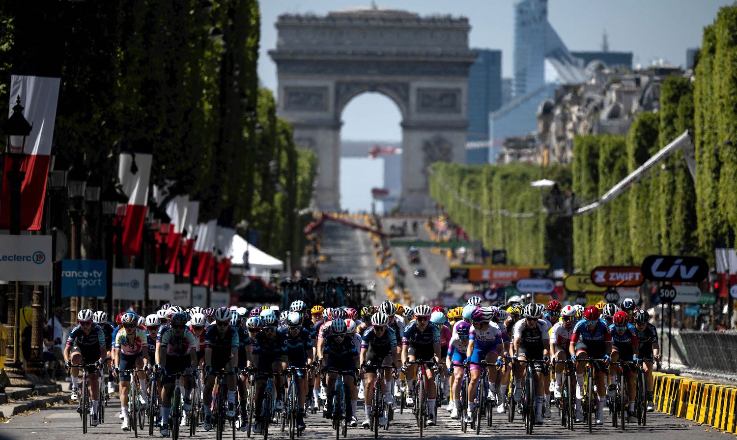 The pack rides on the Champs Elysees during the 1st stage of the new edition of the Women's Tour de France cycling race, 81,6 km between the Tour Eiffel and the Champs-Elysees, in Paris on July 24, 2022. (Photo by JEFF PACHOUD / AFP) (Photo by JEFF PACHOUD/AFP via Getty Images)