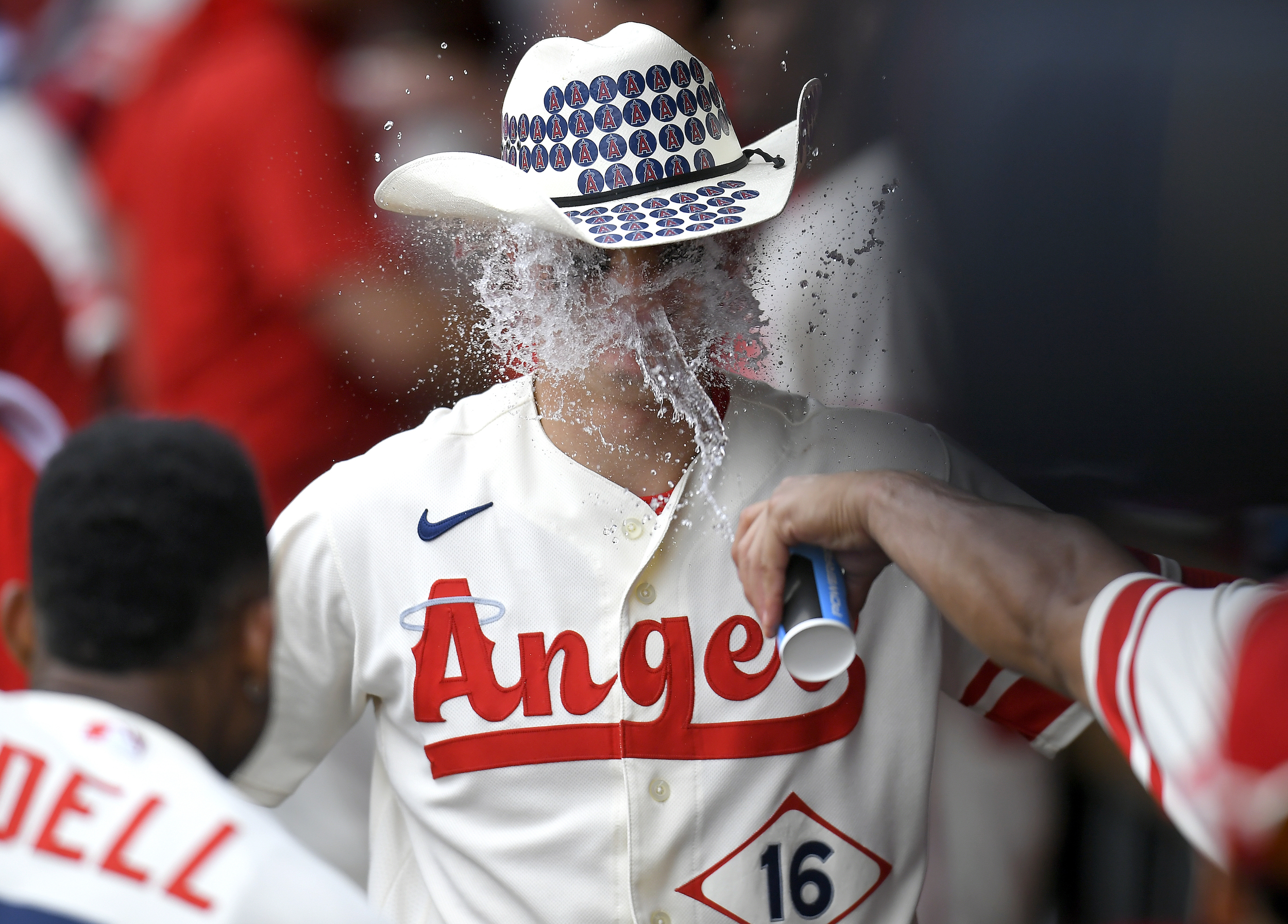 Mickey Moniak of the Los Angeles Angels is congratulated for his home run with a cowboy hat and cup of water to the face in the ninth inning against the Oakland Athletics
