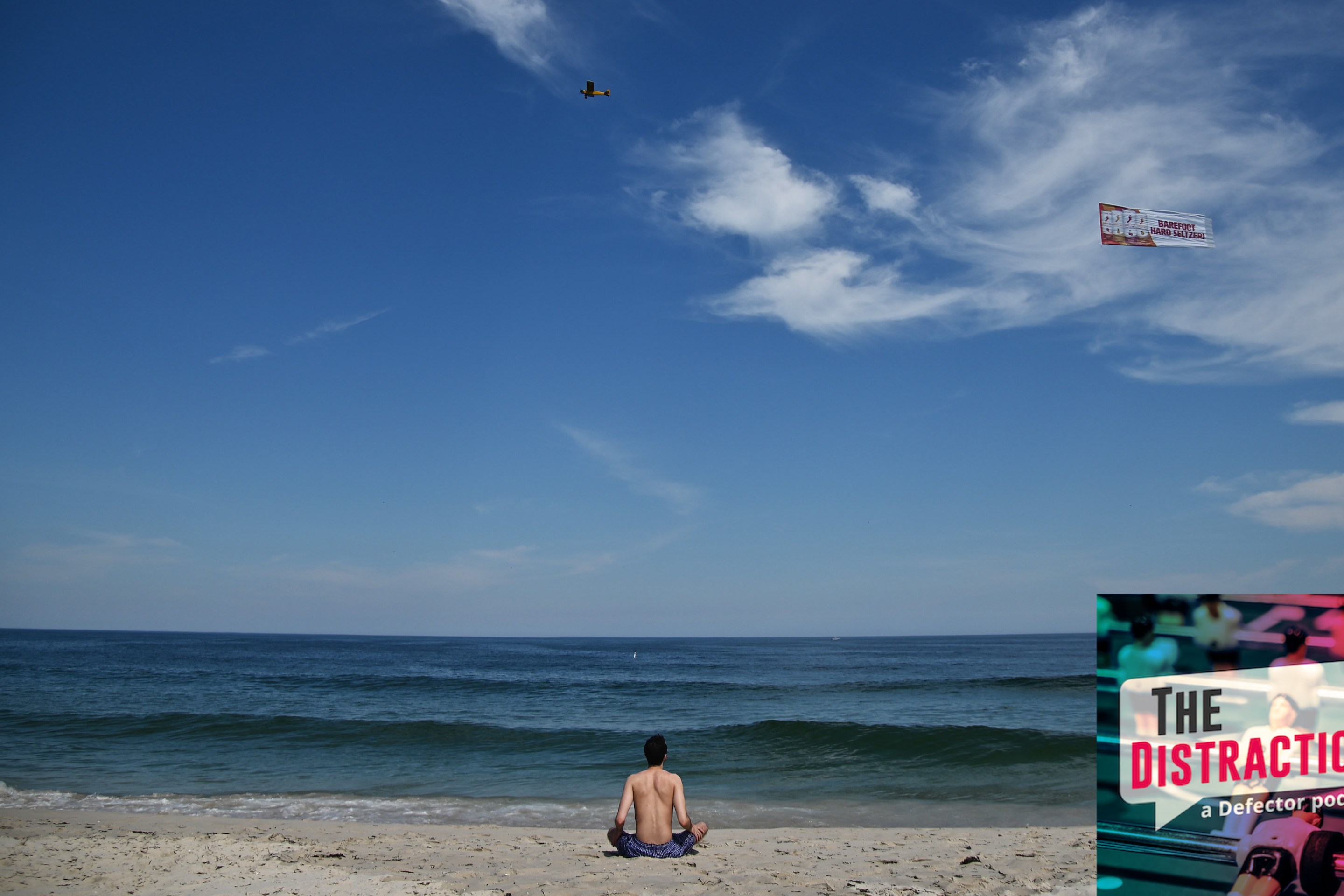 A man sitting on a beach at the Jersey Shore in 2020. He's got a lot of space, which is how you know the photo was from 2020.