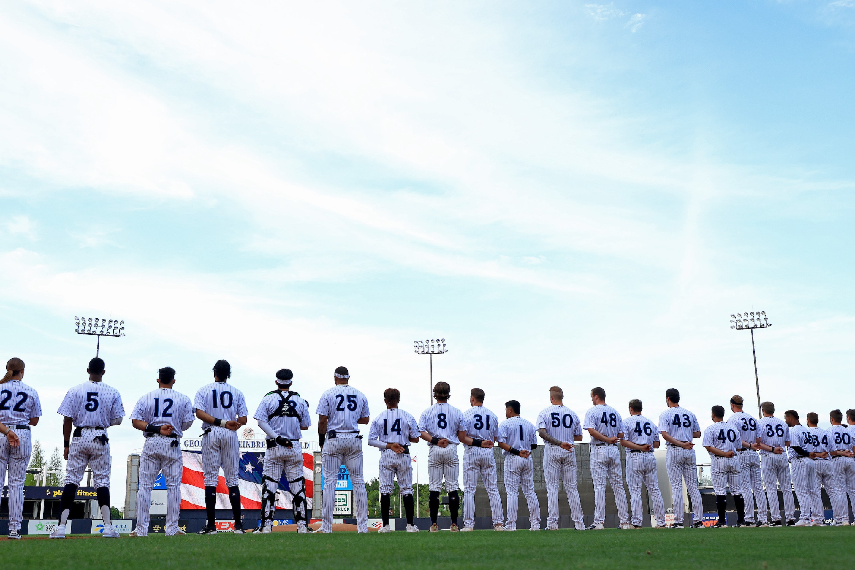 The minor league Tampa Tarpons, under manager Rachel Balkovec, stand for the national anthem in an April 2022 game.