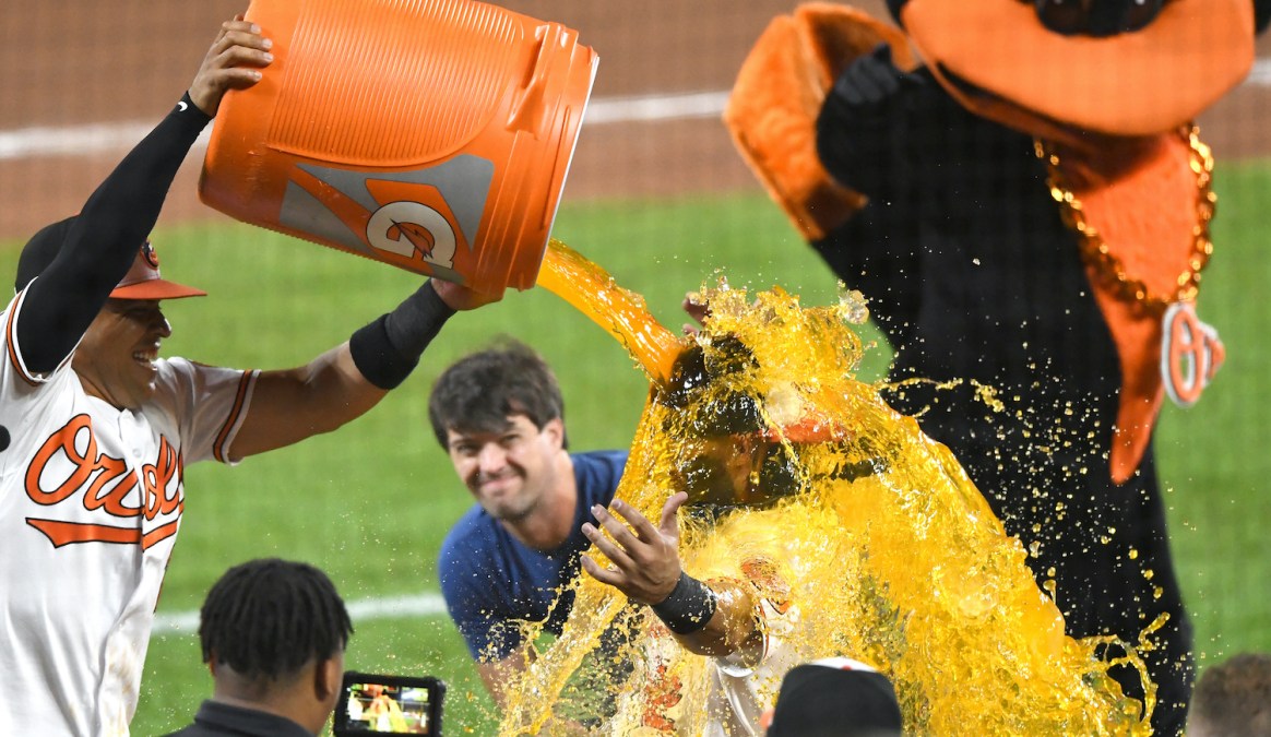 BALTIMORE, MD - AUGUST 09: Robinson Chirinos #23 of the Baltimore Orioles dumps the Gatorade jug over Rougned Odor #12 after winning a baseball game against the Toronto Blue Jays at Oriole Park at Camden Yards on August 09, 2022 in Baltimore, Maryland. (Photo by Mitchell Layton/Getty Images)