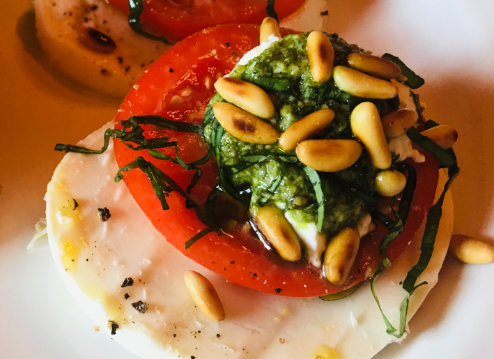 A Caprese salad with pesto and pine nuts