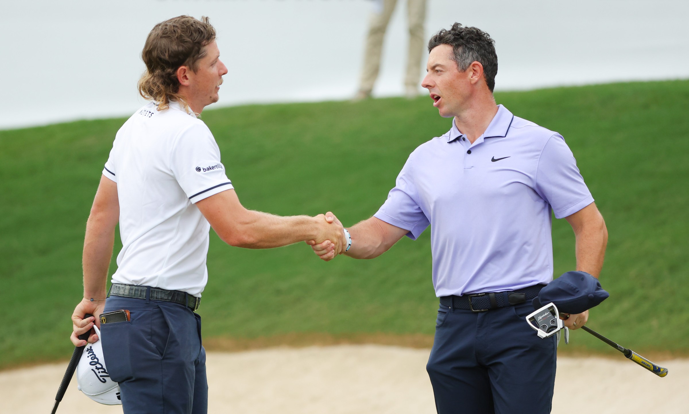 Rory McIlroy shakes hands with Cameron Smith.