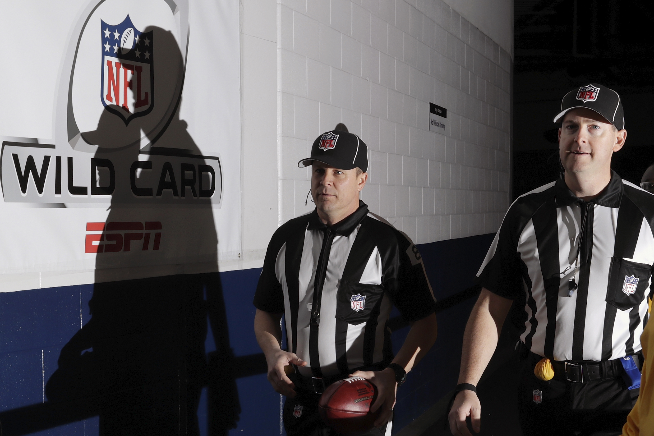 HOUSTON, TX - JANUARY 07: Back judge Shawn  Hochuli #83 and side judge Allen Baynes #56 carry a game ball to the Oakland Raiders locker room before the game against the Houston Texans at NRG Stadium on January 7, 2017 in Houston, Texas. (Photo by Tim Warner/Getty Images)