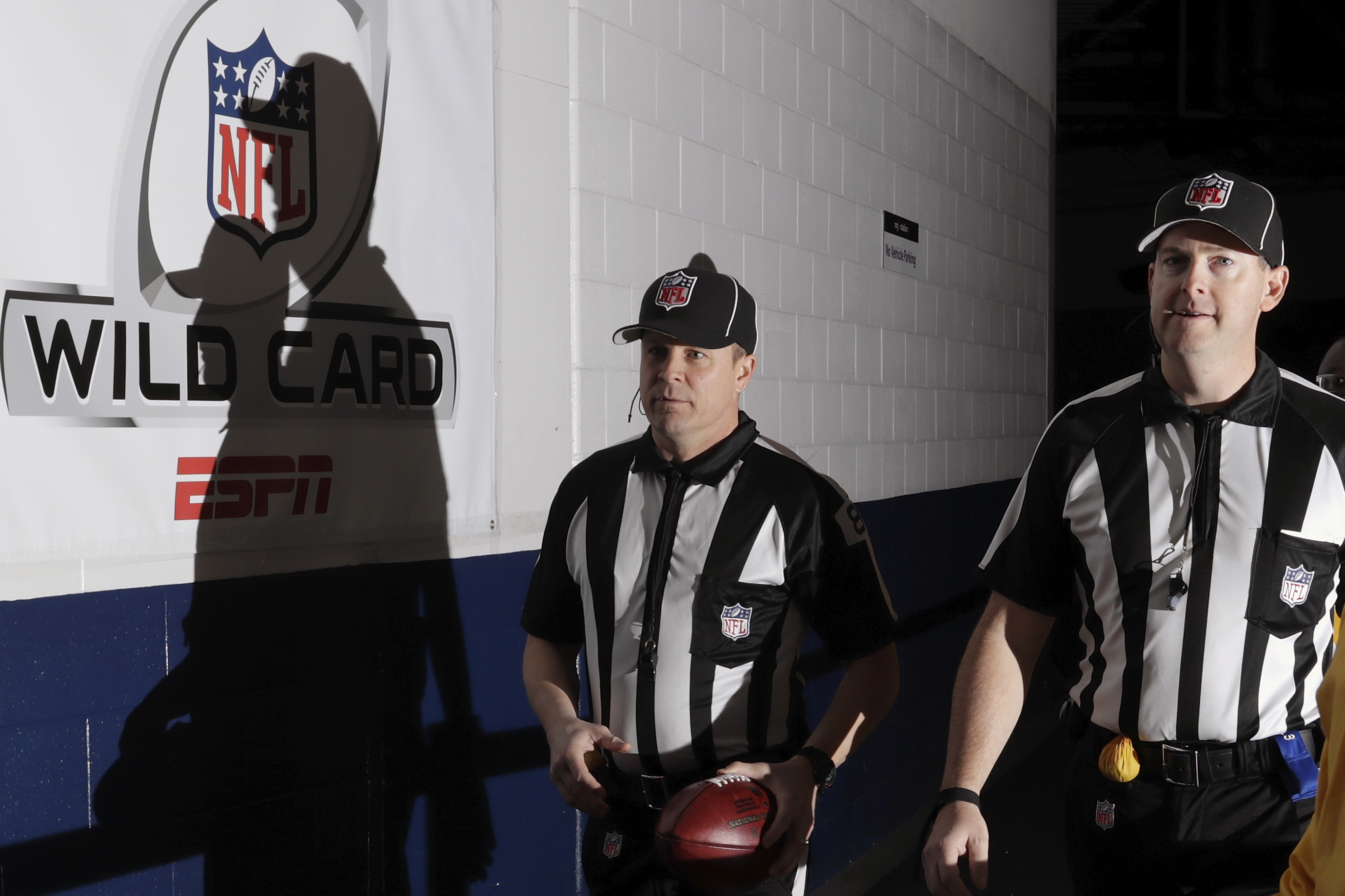 HOUSTON, TX - JANUARY 07: Back judge Shawn Hochuli #83 and side judge Allen Baynes #56 carry a game ball to the Oakland Raiders locker room before the game against the Houston Texans at NRG Stadium on January 7, 2017 in Houston, Texas. (Photo by Tim Warner/Getty Images)