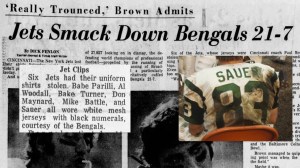 Newspaper background. Story says: "Six Jets had their uniform ritatively cuffed 100 m Bengals 21-7. SAUER ns, le el shirts stolen. Babe Parilli, Al seco ond m Wandala Bake , Twinet Don Mike Battle, and Sauer all wore white mesh jerseys with black numerals, courtesy of the Bengals."
