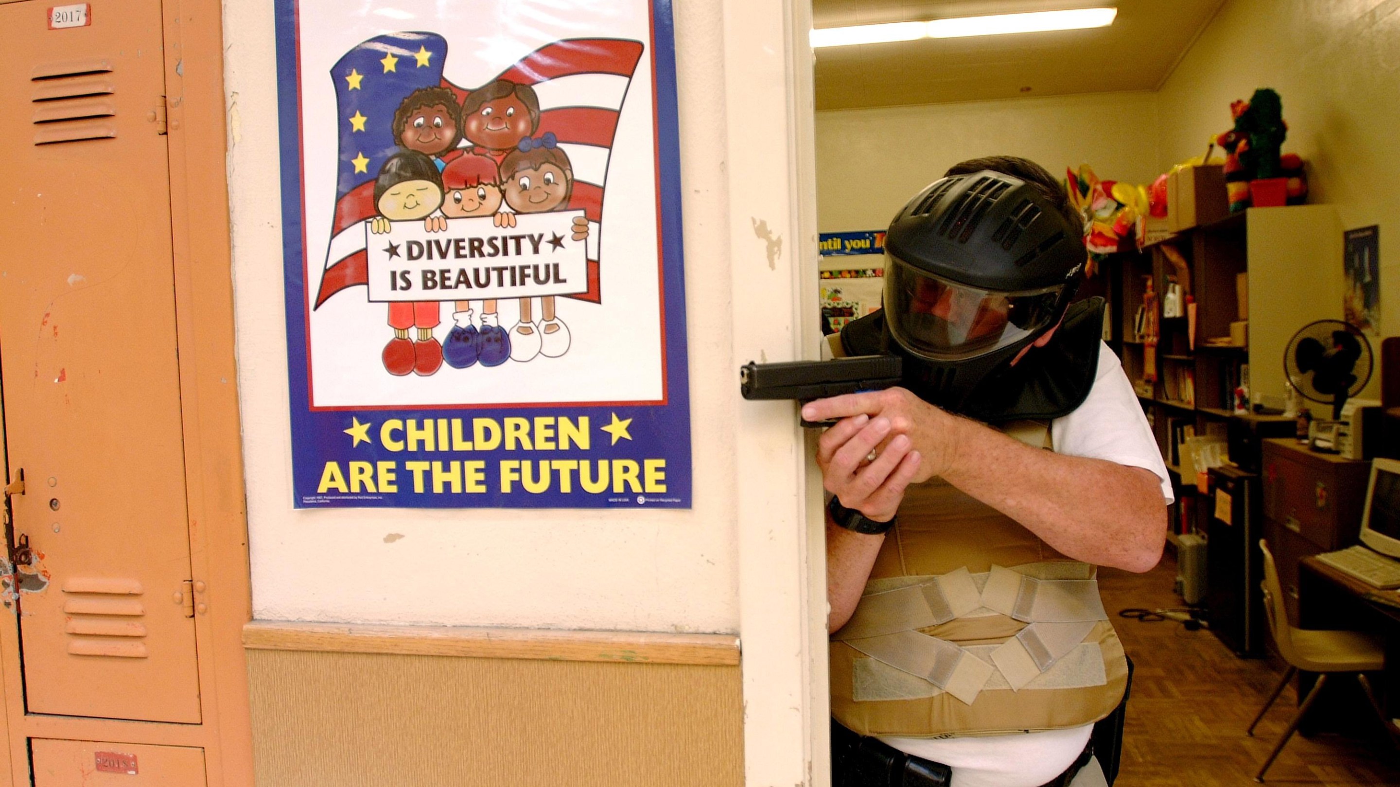 HUNTINGTON BEACH CA - FEBRUARY 4 : A SWAT team member enacts defense against school violence . SWAT teams from many Police forces throughout America and Canada participate in a realistic training exercises at various High Schools throughout America to help combat the rise in shooting and violence on Campus. April 19, 2001 Huntington Beach High School, Huntington Beach California (Photo By Paul Harris/Getty Images)