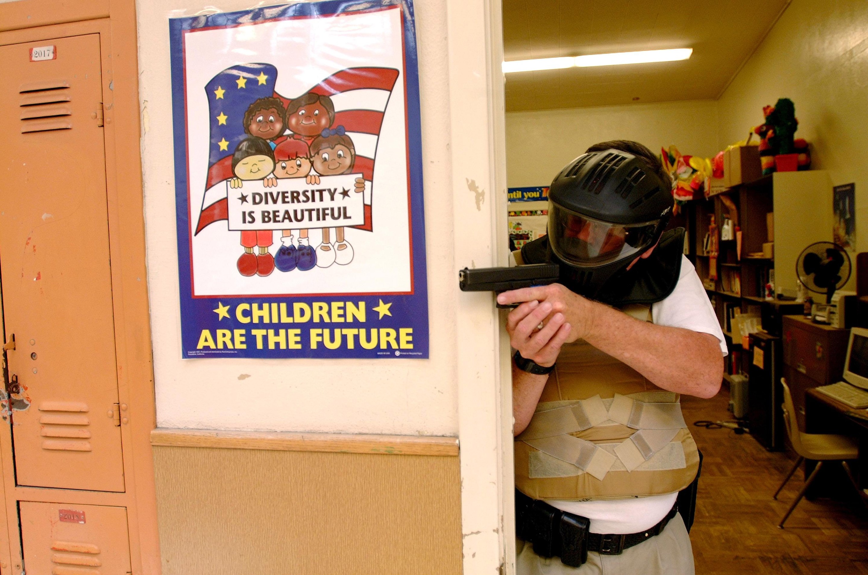 HUNTINGTON BEACH CA - FEBRUARY 4 : A SWAT team member enacts defense against school violence . SWAT teams from many Police forces throughout America and Canada participate in a realistic training exercises at various High Schools throughout America to help combat the rise in shooting and violence on Campus. April 19, 2001 Huntington Beach High School, Huntington Beach California (Photo By Paul Harris/Getty Images)