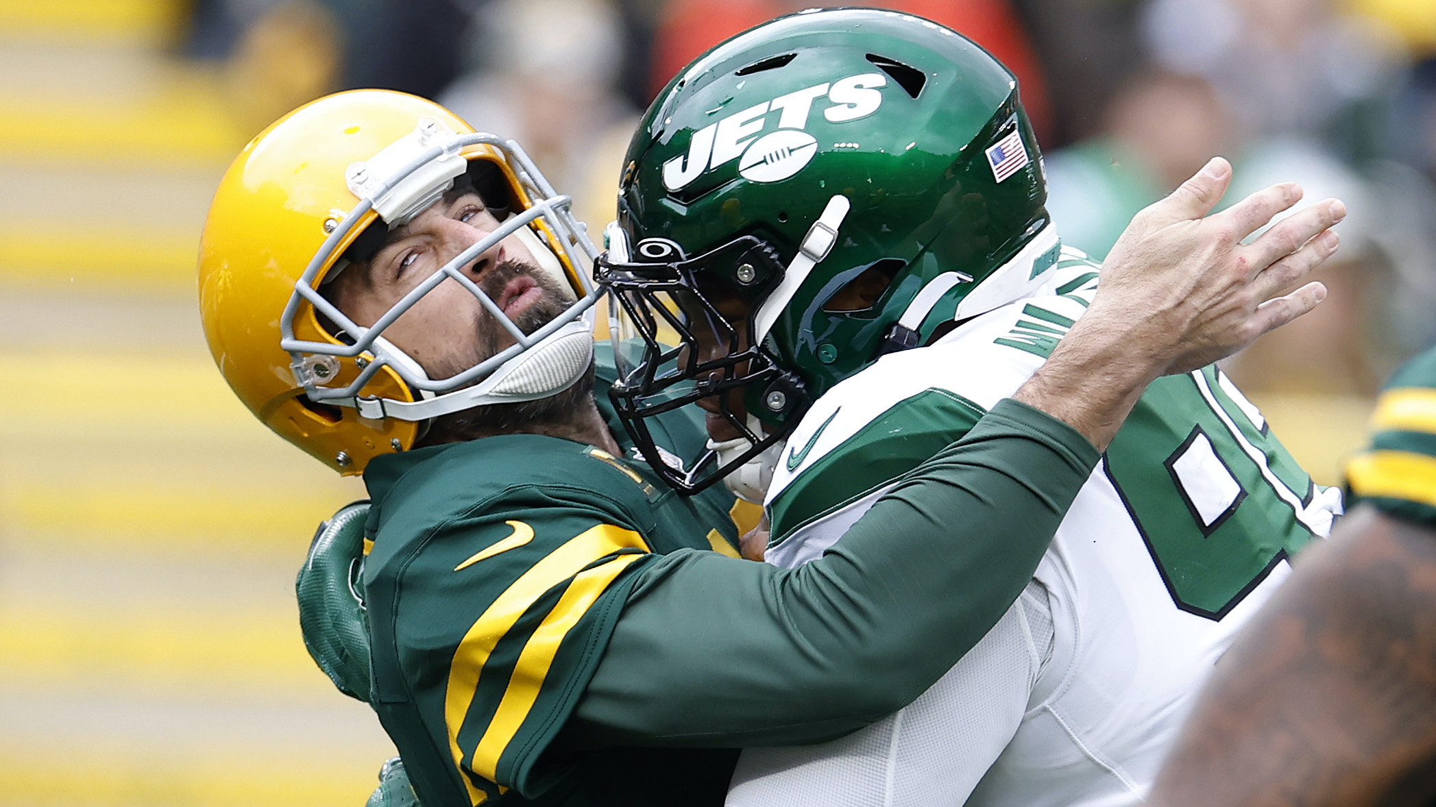 Aaron Rodgers takes a hit from a Jets defender.