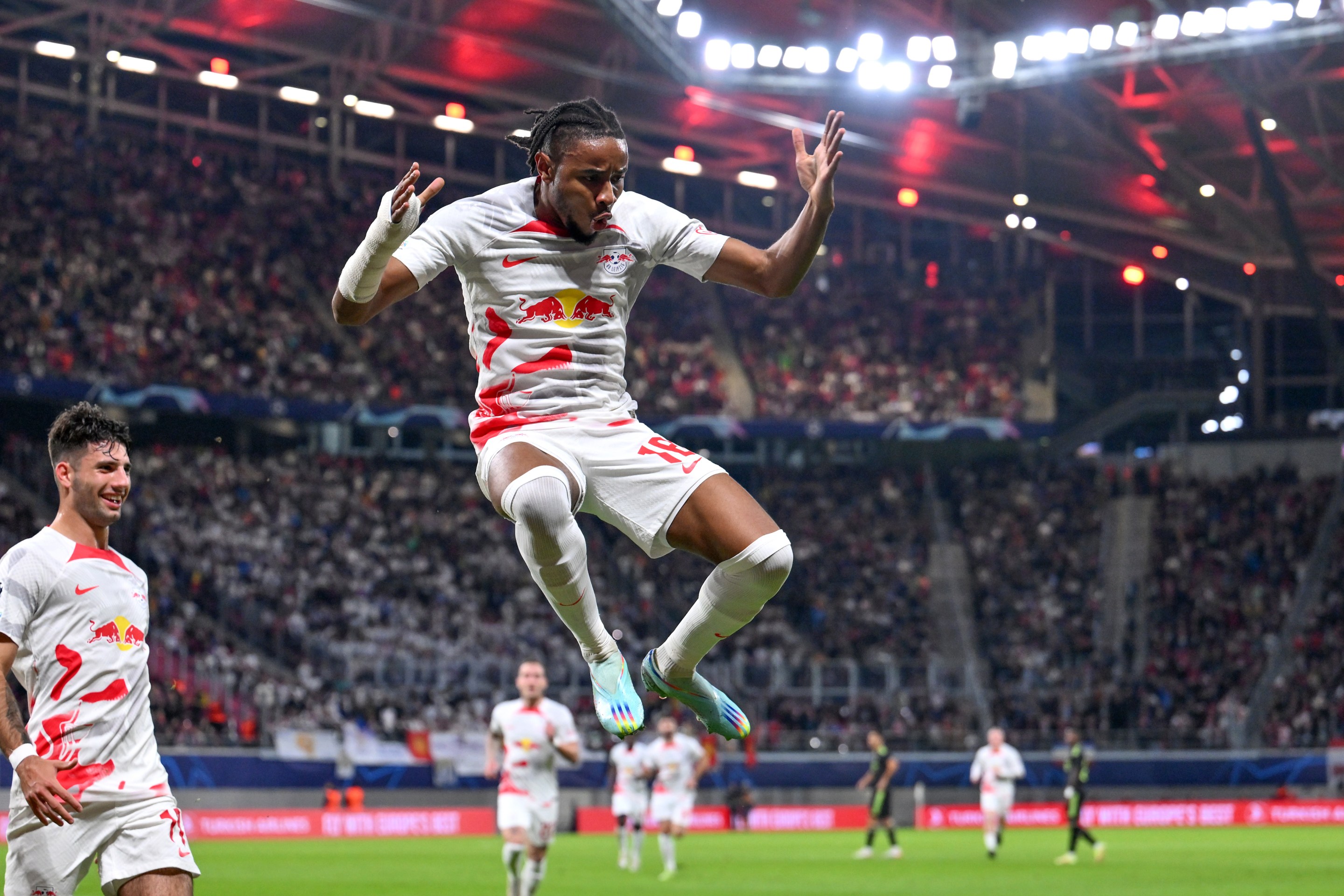 Christopher Nkunku of RB Leipzig celebrates scoring their side's second goal with teammates during the UEFA Champions League group F match between RB Leipzig and Real Madrid at Red Bull Arena on October 25, 2022 in Leipzig, Germany.