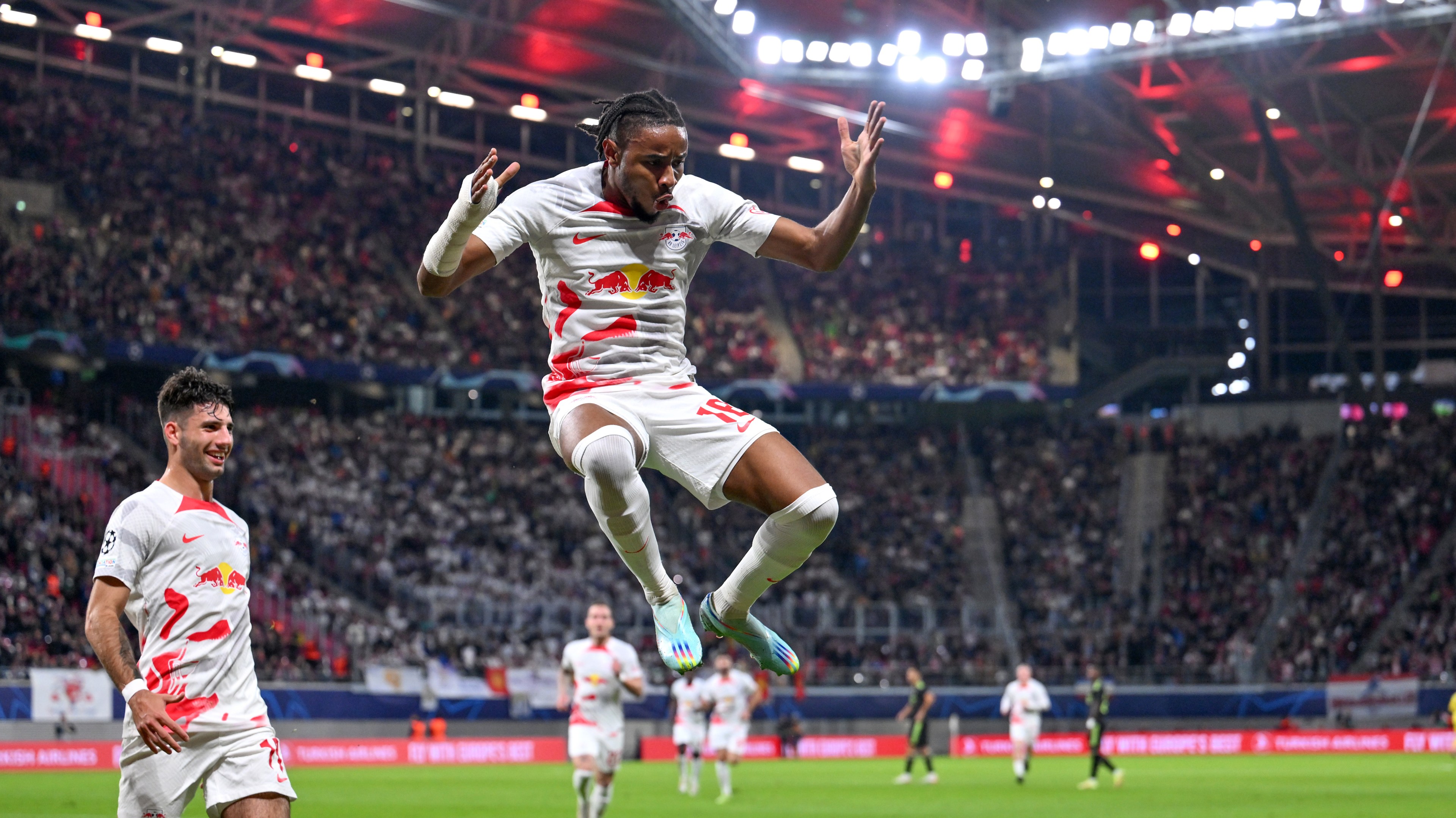 Christopher Nkunku of RB Leipzig celebrates scoring their side's second goal with teammates during the UEFA Champions League group F match between RB Leipzig and Real Madrid at Red Bull Arena on October 25, 2022 in Leipzig, Germany.