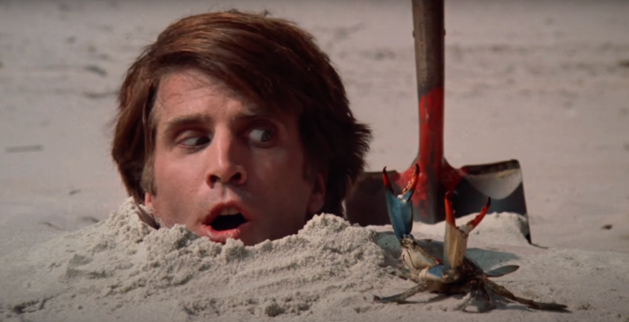 Ted Danson buried up to his neck in sand, being menaced by a crab, in the movie Creepshow