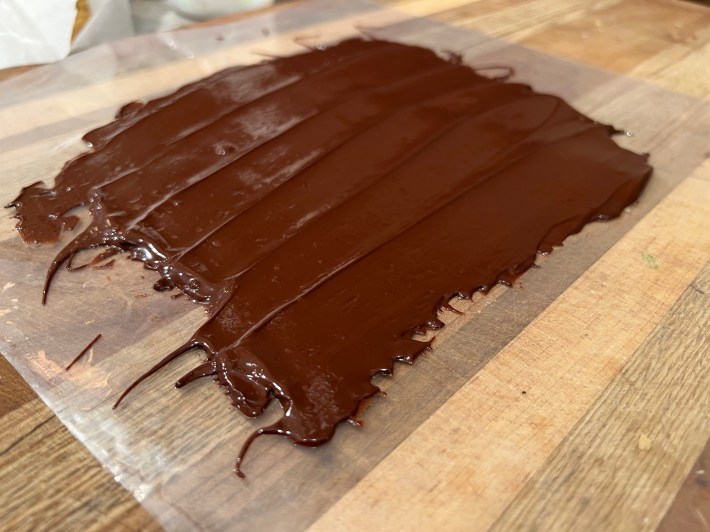 Tempered chocolate spread on an acetate sheet.