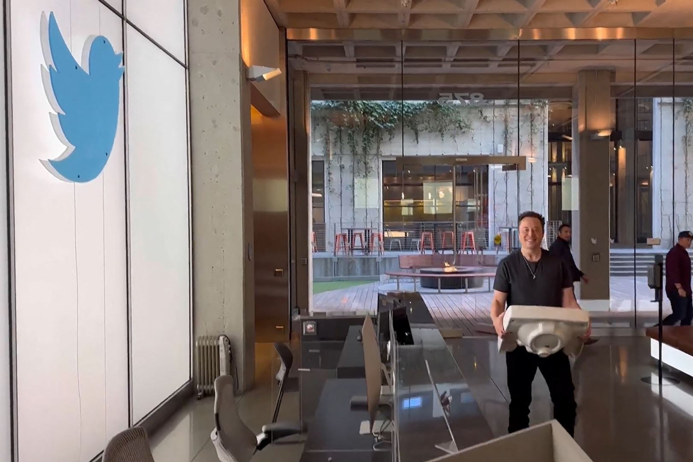 Twitter CEO Elon Musk carries a sink into Twitter headquarters as part of a typically epic jape.