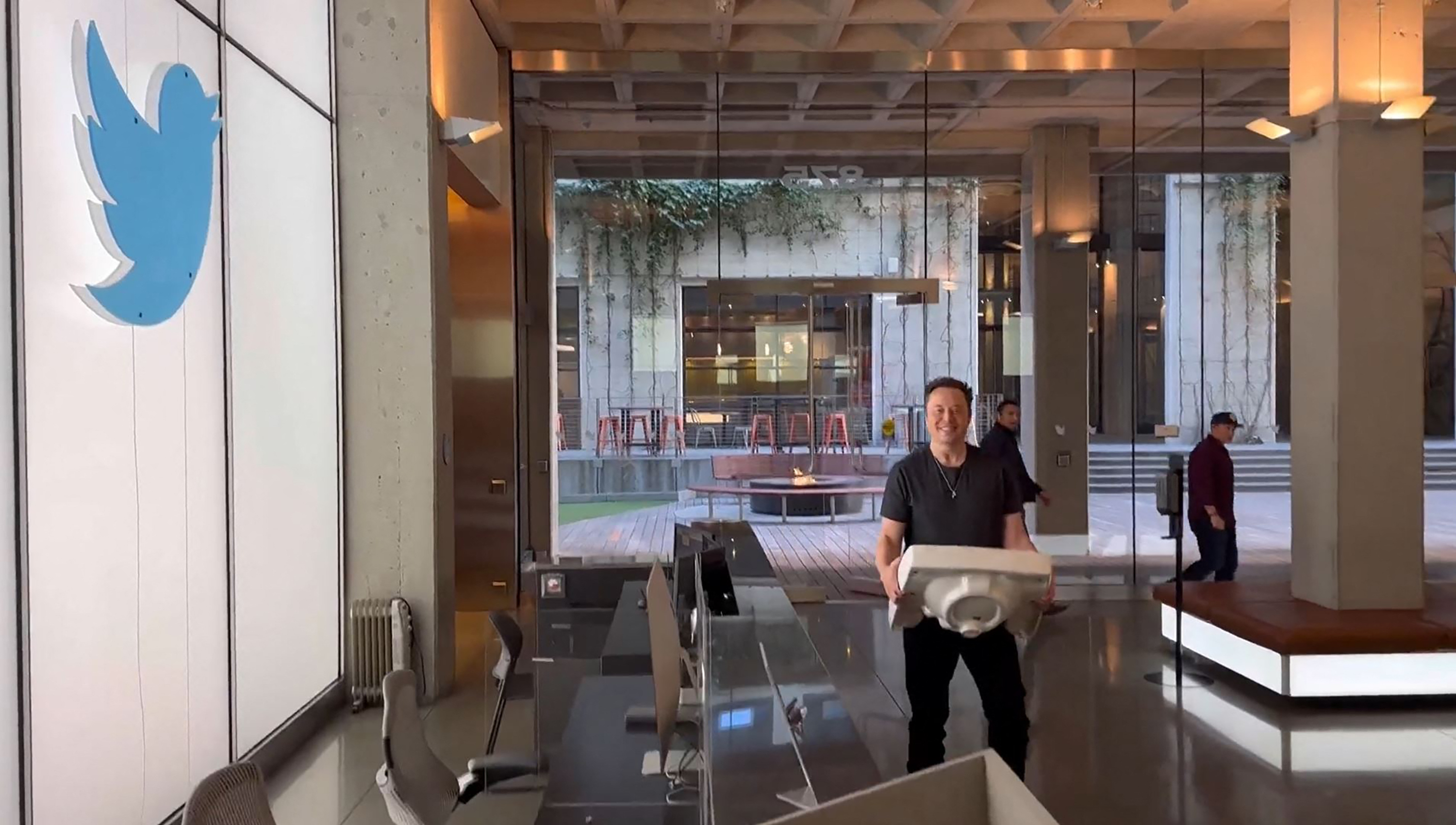 Twitter CEO Elon Musk carries a sink into Twitter headquarters as part of a typically epic jape.