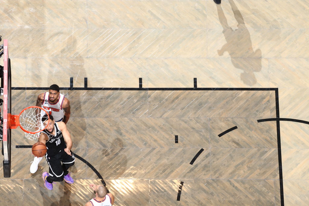 Ben Simmons scores while Obi Toppin looks on.