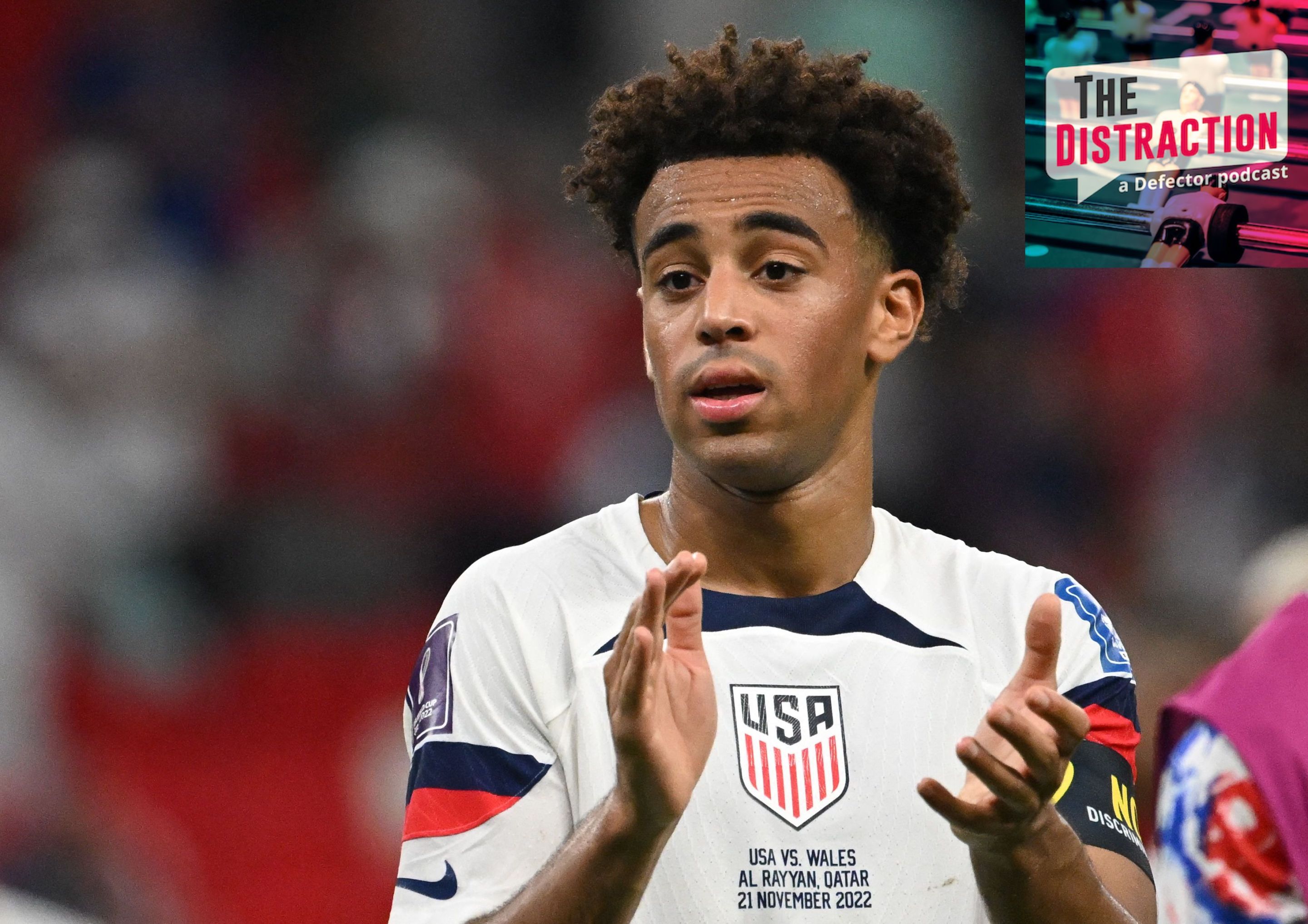 USMNT midfielder Tyler Adams applauds after the team's 1-1 tie against Wales in the 2022 World Cup. The Distraction logo is at upper right.