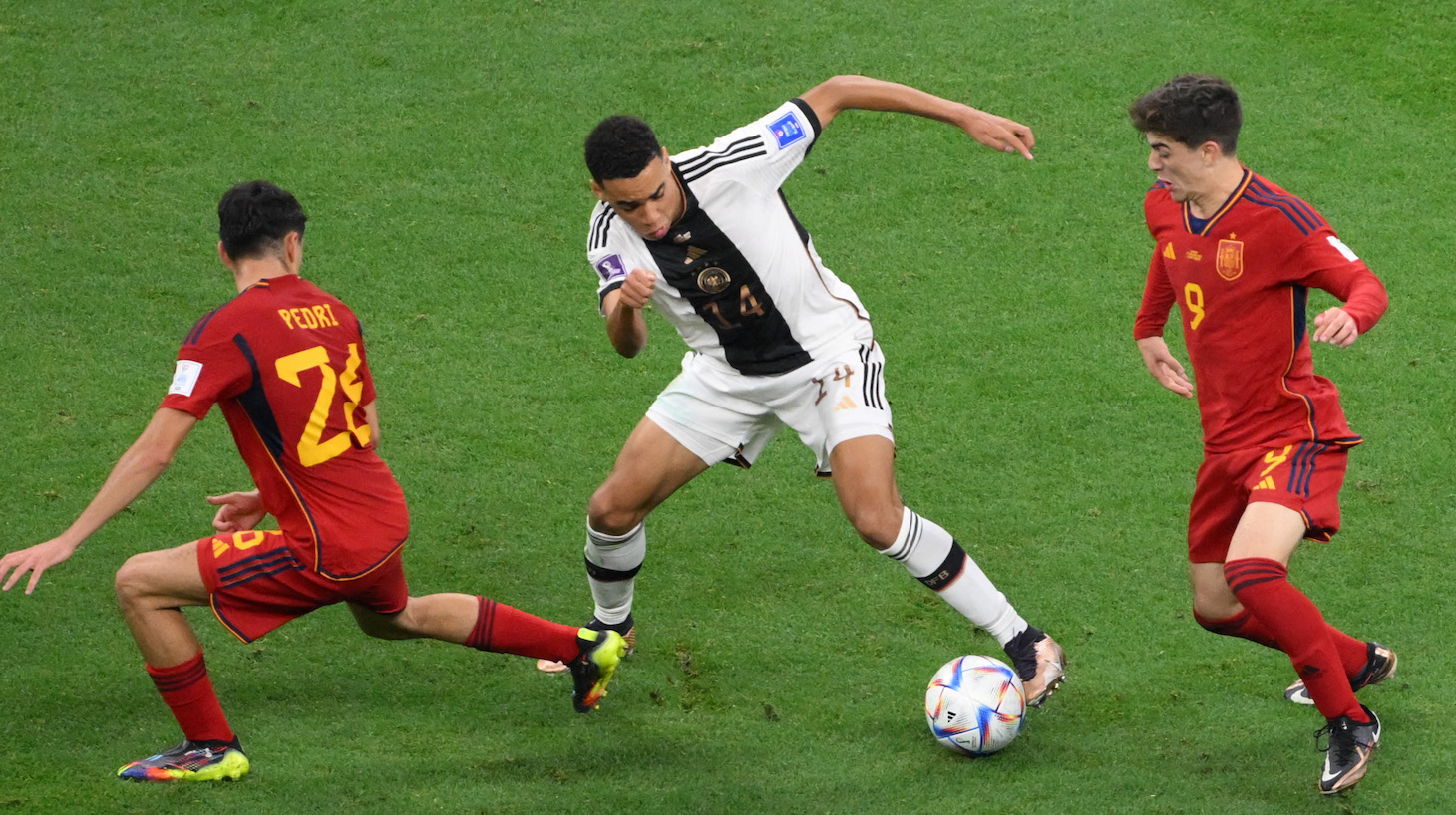 Germany's midfielder #14 Jamal Musiala is challenged by Spain's midfielder #26 Pedri and Spain's midfielder #09 Gavi during the Qatar 2022 World Cup Group E football match between Spain and Germany at the Al-Bayt Stadium in Al Khor, north of Doha on November 27, 2022.