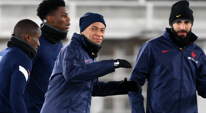 Some France national team guys in cold-weather workout clothes, prominently featuring Kylian Mbappé and Karim Benzema