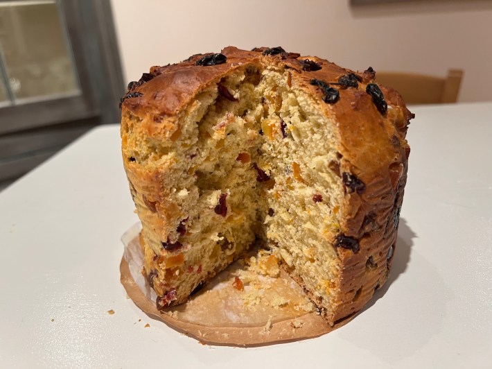 A finished panettone with one slice removed.