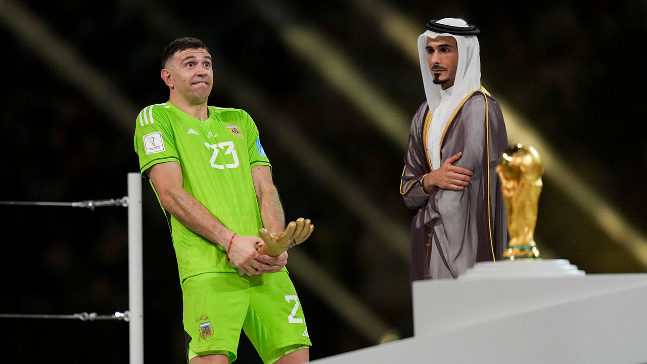 LUSAIL CITY, QATAR - DECEMBER 18: goalkeeper Emiliano Martinez of Argentina celebrates receiving the trophy for best goalkeeper of the tournament after the FIFA World Cup Qatar 2022 Final match between Argentina and France at Lusail Stadium on December 18, 2022 in Lusail City, Qatar.
