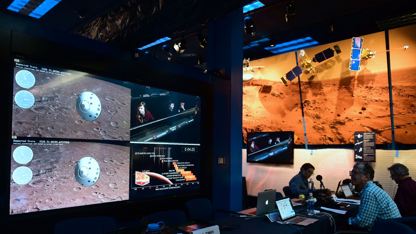 People watch the landing of NASA's InSight spacecraft on the planet Mars on television screens at NASA's Jet Propulsion Laboratory (JPL) in Pasadena, California on November 26, 2018. - Cheers and applause erupted at NASA's Jet Propulsion Laboratory as a $993 million unmanned lander, called InSight, touched down on the Red Planet and managed to send back its first picture. (Photo by Frederic J. BROWN / AFP) (Photo credit should read FREDERIC J. BROWN/AFP via Getty Images)