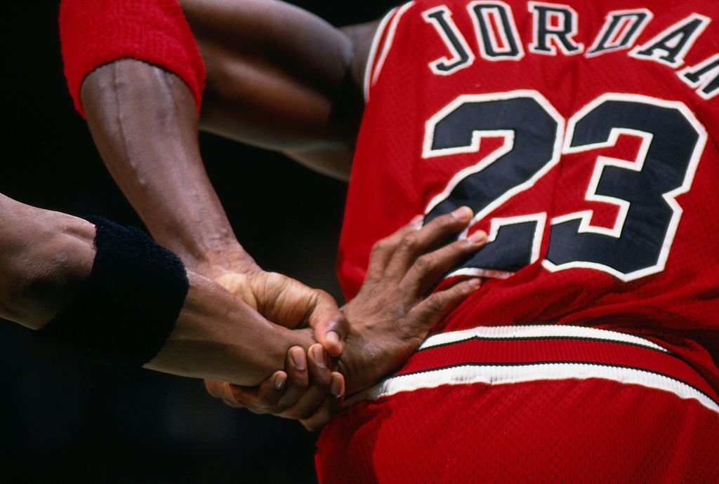 A defender grabs Michael Jordan's jersey.
