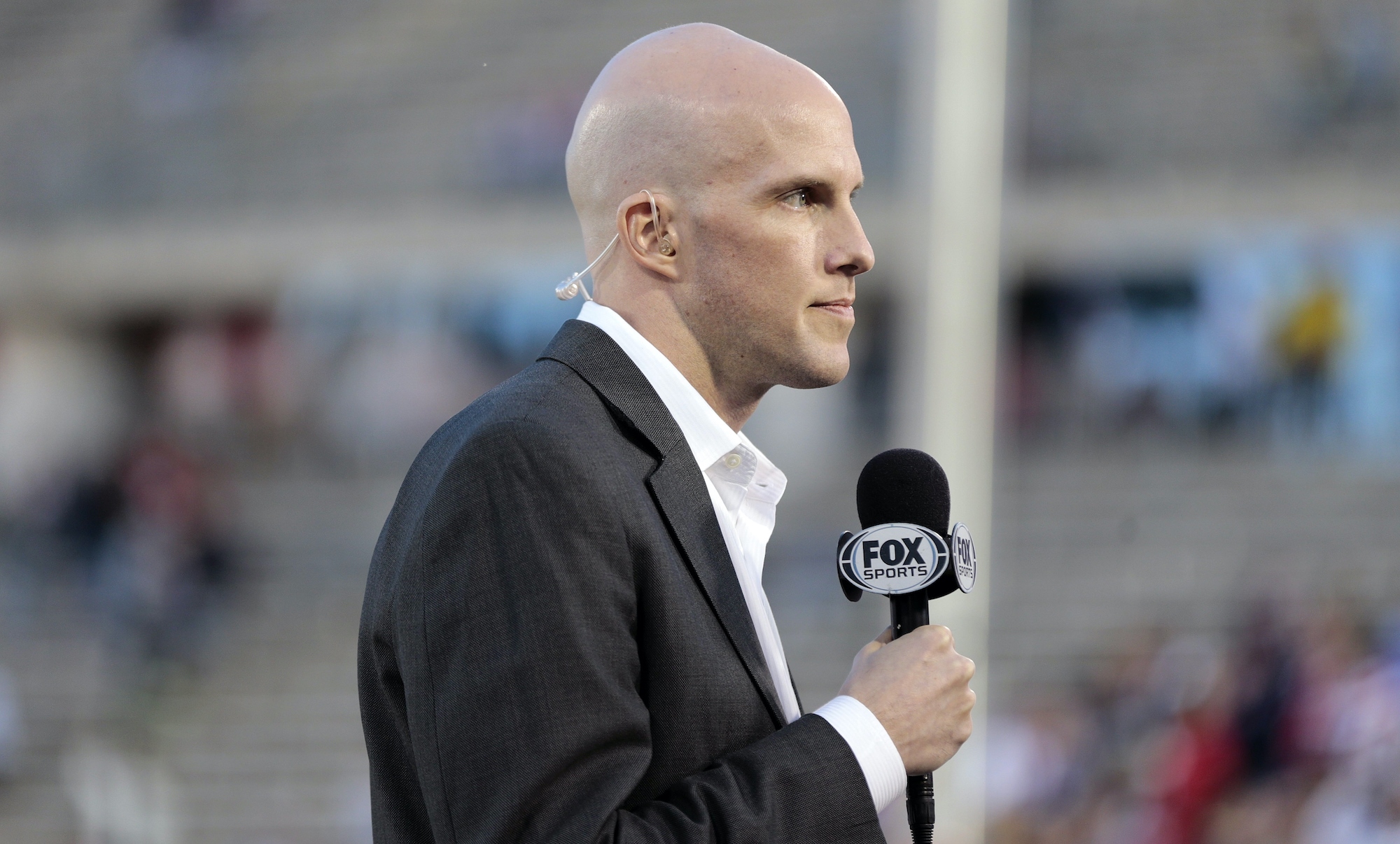 Grant Wahl holds a microphone while covering an international friendly.