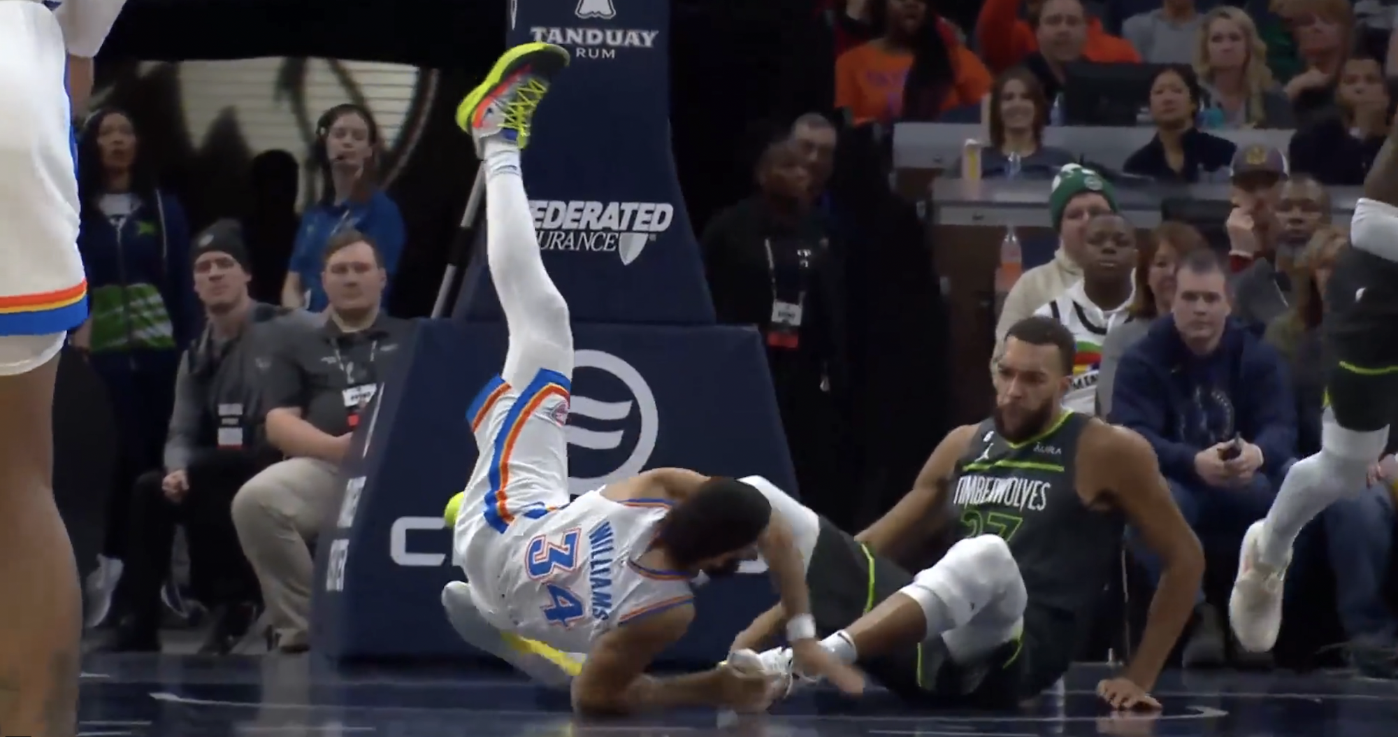 Rudy Gobert and Kenrich Williams fall to the floor.
