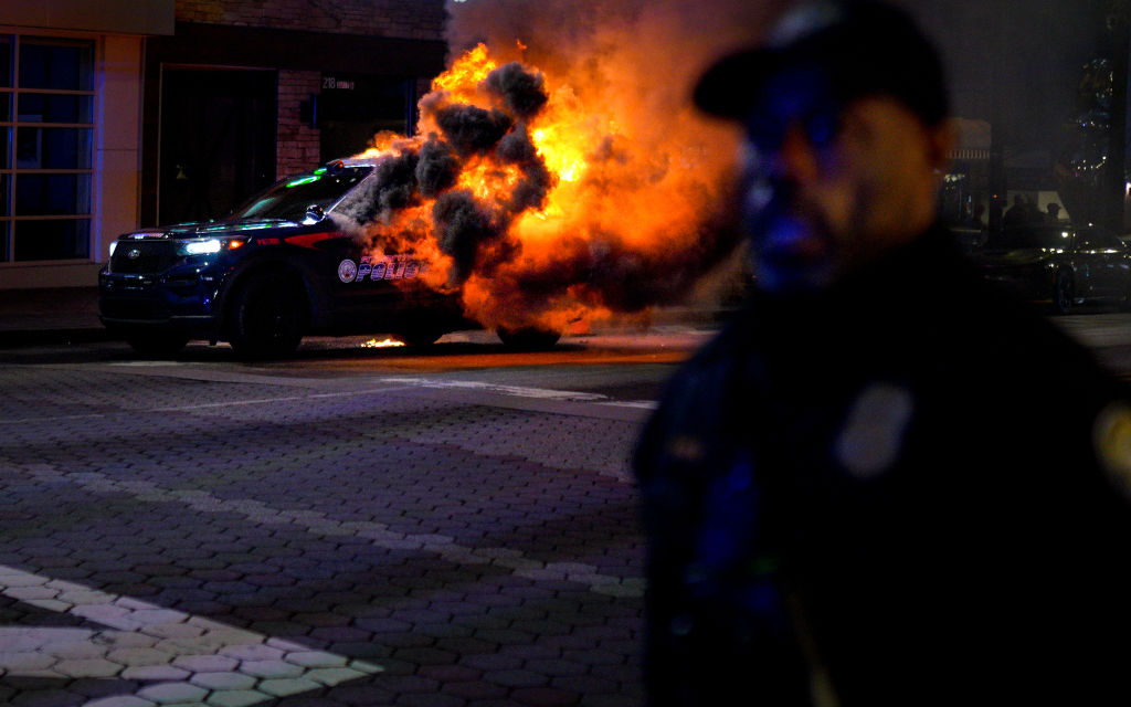 ATLANTA, USA - JANUARY 21: Firefighters work to extinguish a fire after an Atlanta police vehicle was set on fire during a "Stop cop city" protest in Atlanta, Georgia, United States on January 21, 2023. Multiple buildings were vandalized and an Atlanta police vehicle was set on fire as multiple arrests were made. (Photo by Benjamin Hendren/Anadolu Agency via Getty Images)