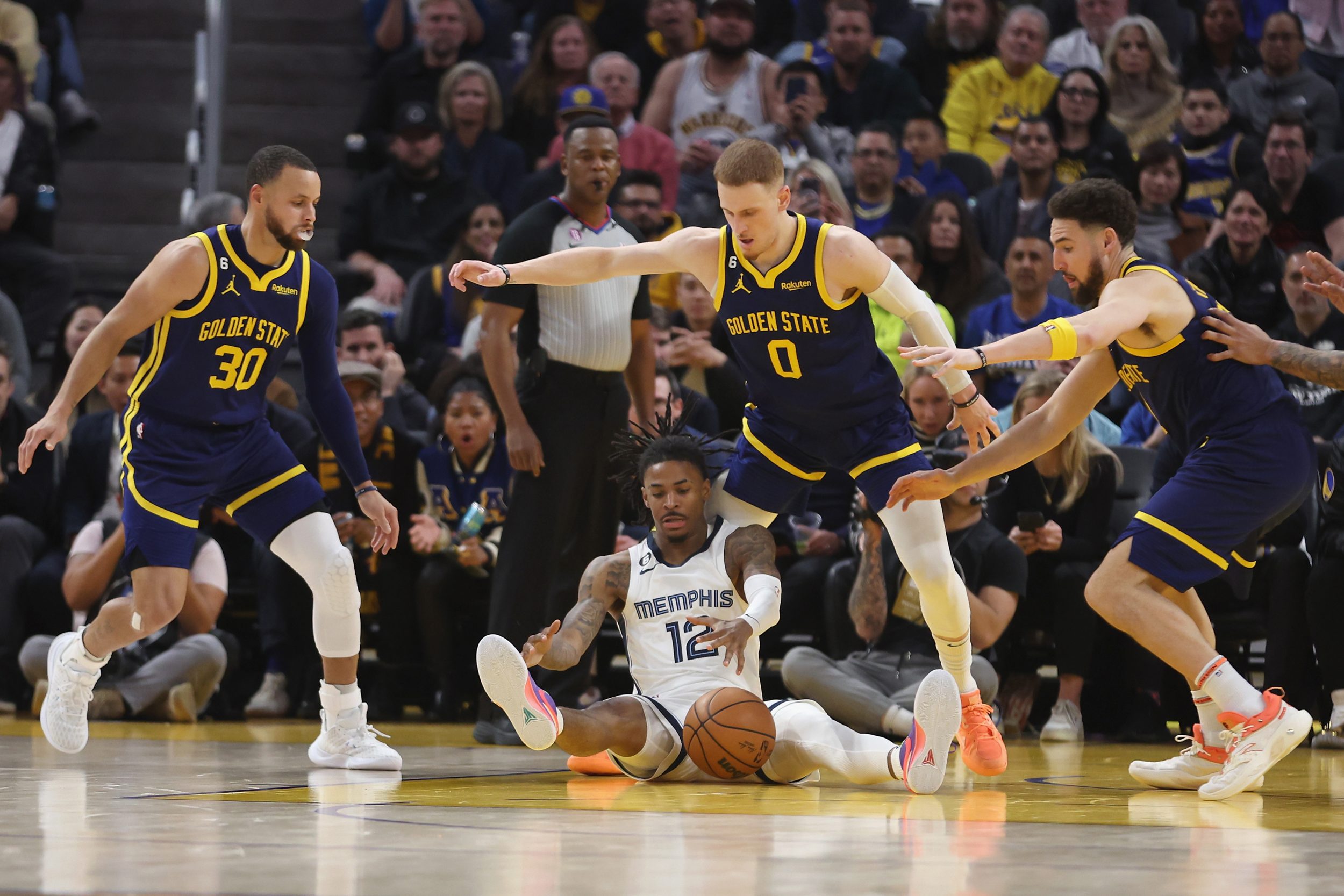 SAN FRANCISCO, CALIFORNIA - JANUARY 25: Ja Morant #12 of the Memphis Grizzlies competes for the loose ball against Stephen Curry #30, Donte DiVincenzo #0 and Klay Thompson #11 of the Golden State Warriors in the fourth quarter at Chase Center on January 25, 2023 in San Francisco, California. NOTE TO USER: User expressly acknowledges and agrees that, by downloading and/or using this photograph, User is consenting to the terms and conditions of the Getty Images License Agreement. (Photo by Lachlan Cunningham/Getty Images)