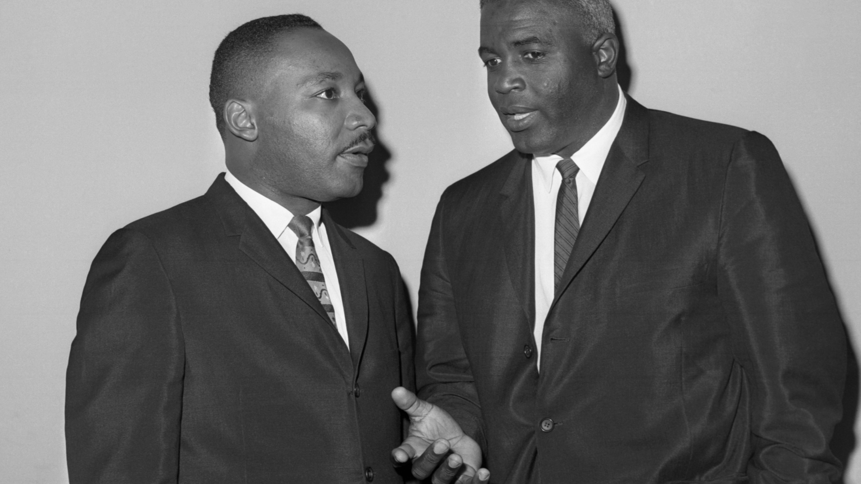Jackie Robinson and the Rev. Dr. Martin Luther King talk before a press conference as part of their campaign against segregation in 1962.
