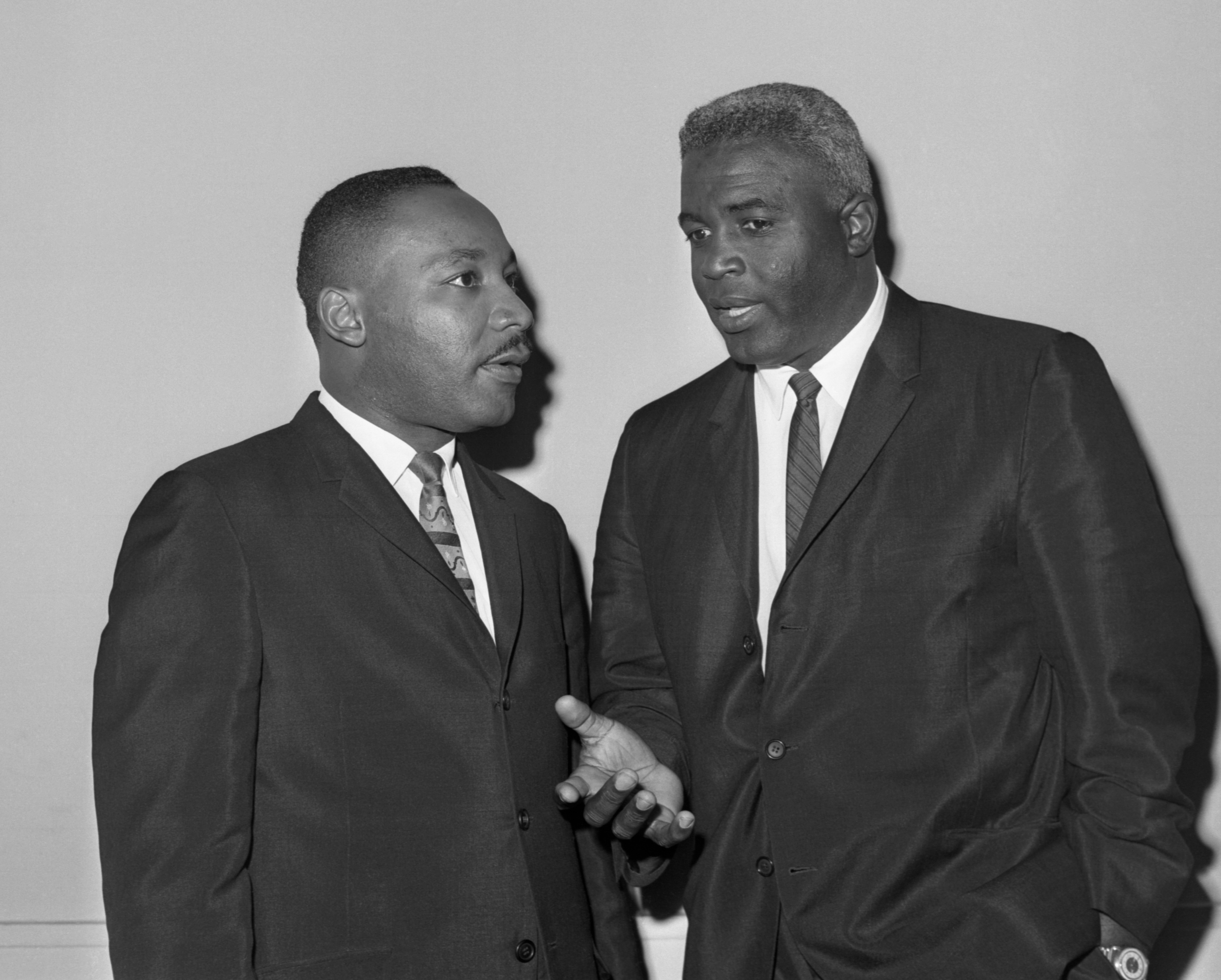 Jackie Robinson and the Rev. Dr. Martin Luther King talk before a press conference as part of their campaign against segregation in 1962.