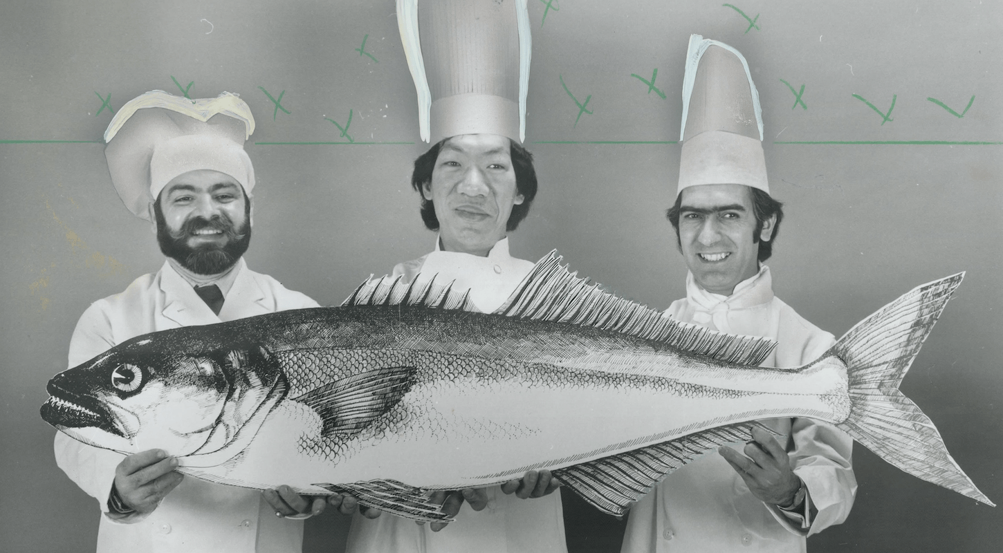 Three chefs hold a giant fish in an old black-and-white photo