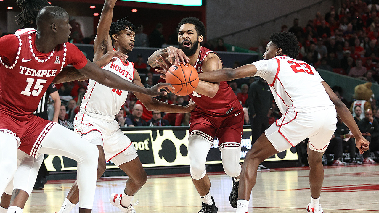 HOUSTON, TEXAS - JANUARY 22: Damian Dunn #1 of the Temple Owls is fouled by Terrance Arceneaux #23 of the Houston Cougars as he drives to the basket during the first halfat Fertitta Center on January 22, 2023 in Houston, Texas.