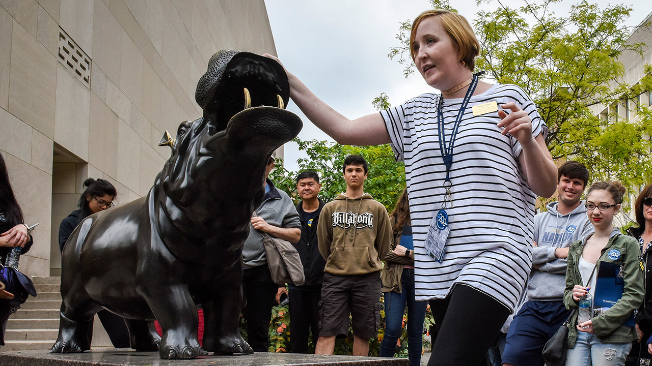 WASHINGTON, DC - APRIL 26: Sophomore Paige James, center, touches a hippo statue for luck as she leads admitted George Washington University students and their parents on a tour of the campus before deciding on whether or not to enroll on April, 26, 2017 in Washington, DC.