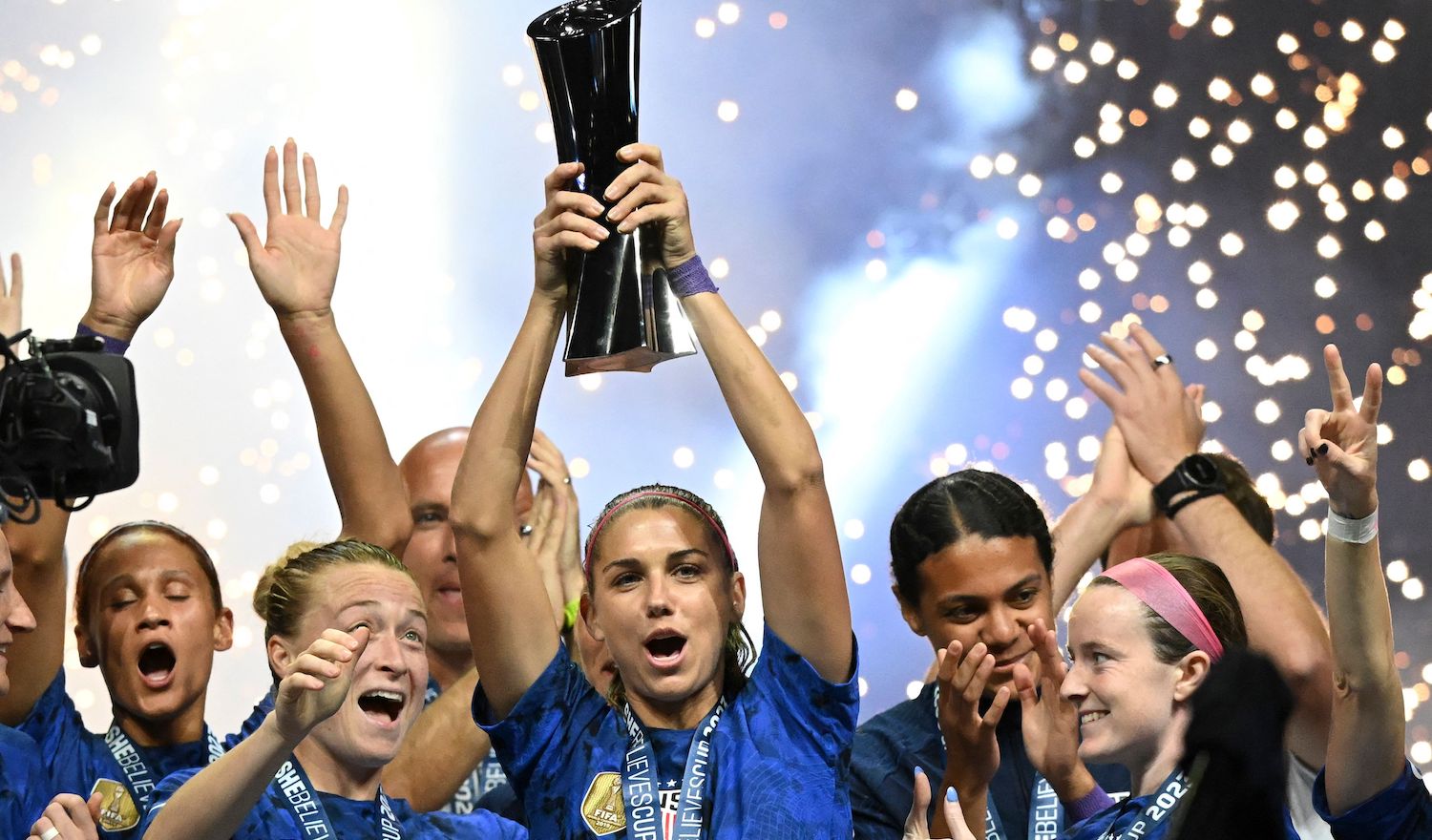 TOPSHOT - United States forward Alex Morgan (C) raises the SheBelieves Cup trophy as the United States Womens National Soccer Team celebrates following the 2023 SheBelieves Cup soccer match between the United States and Brazil at Toyota Stadium in Frisco, Texas, on February 22, 2023. (Photo by Patrick T. Fallon / AFP) (Photo by PATRICK T. FALLON/AFP via Getty Images)