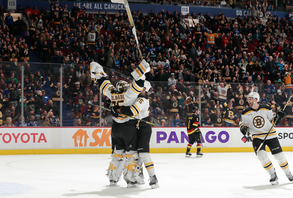 Linus Ullmark #35 of the Boston Bruins is congratulated by teammate Brandon Carlo #25 after scoring a goalie goal during their NHL game against the Vancouver Canucks at Rogers Arena February 25, 2023 in Vancouver, British Columbia, Canada. (Photo by Jeff Vinnick/NHLI via Getty Images)