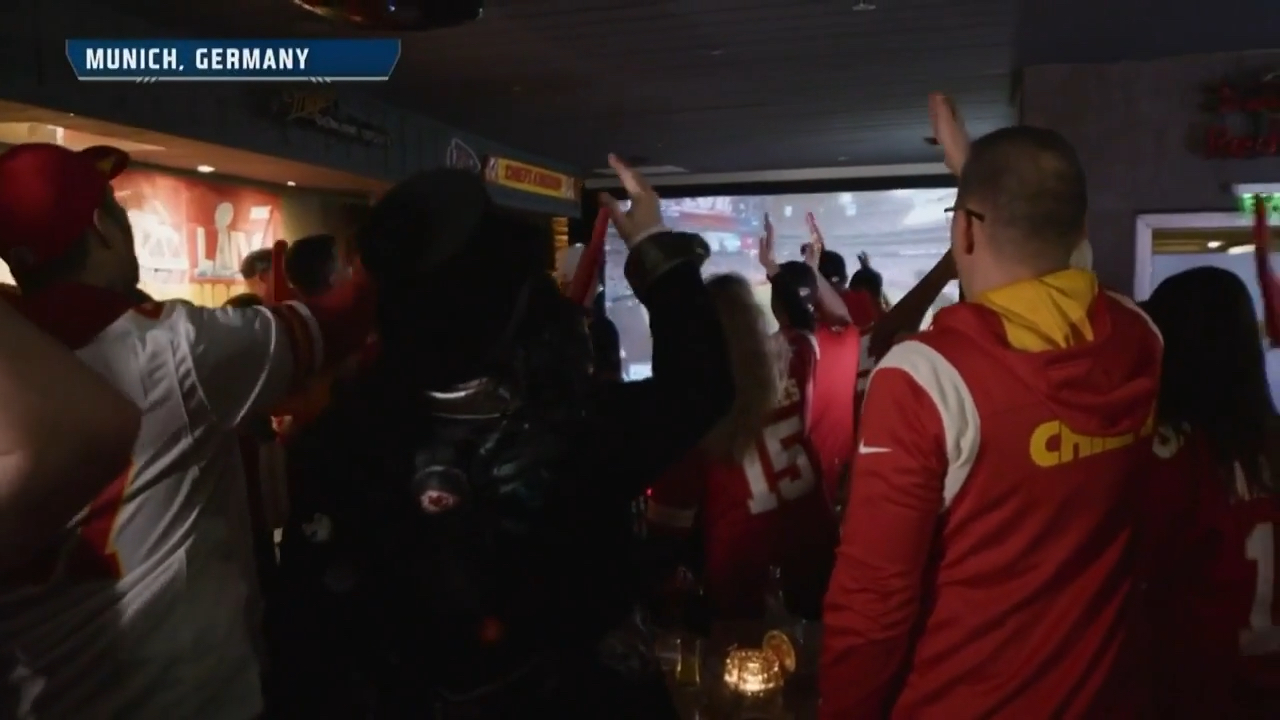 Kansas City Chiefs fans in Germany do the Tomahawk Chop during Super Bowl 57.