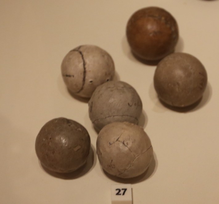 Old leather-covered golf balls stuffed with goose feathers and dyed.