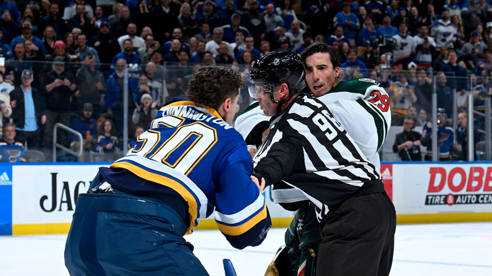 ST. LOUIS, MO - MARCH 15: Marc-Andre Fleury #29 of the Minnesota Wild attempts to get physical with Jordan Binnington #50 of the St. Louis Blues but is stopped by linesman Dan Kelly #98 at the Enterprise Center on March 15, 2023 in St. Louis, Missouri.