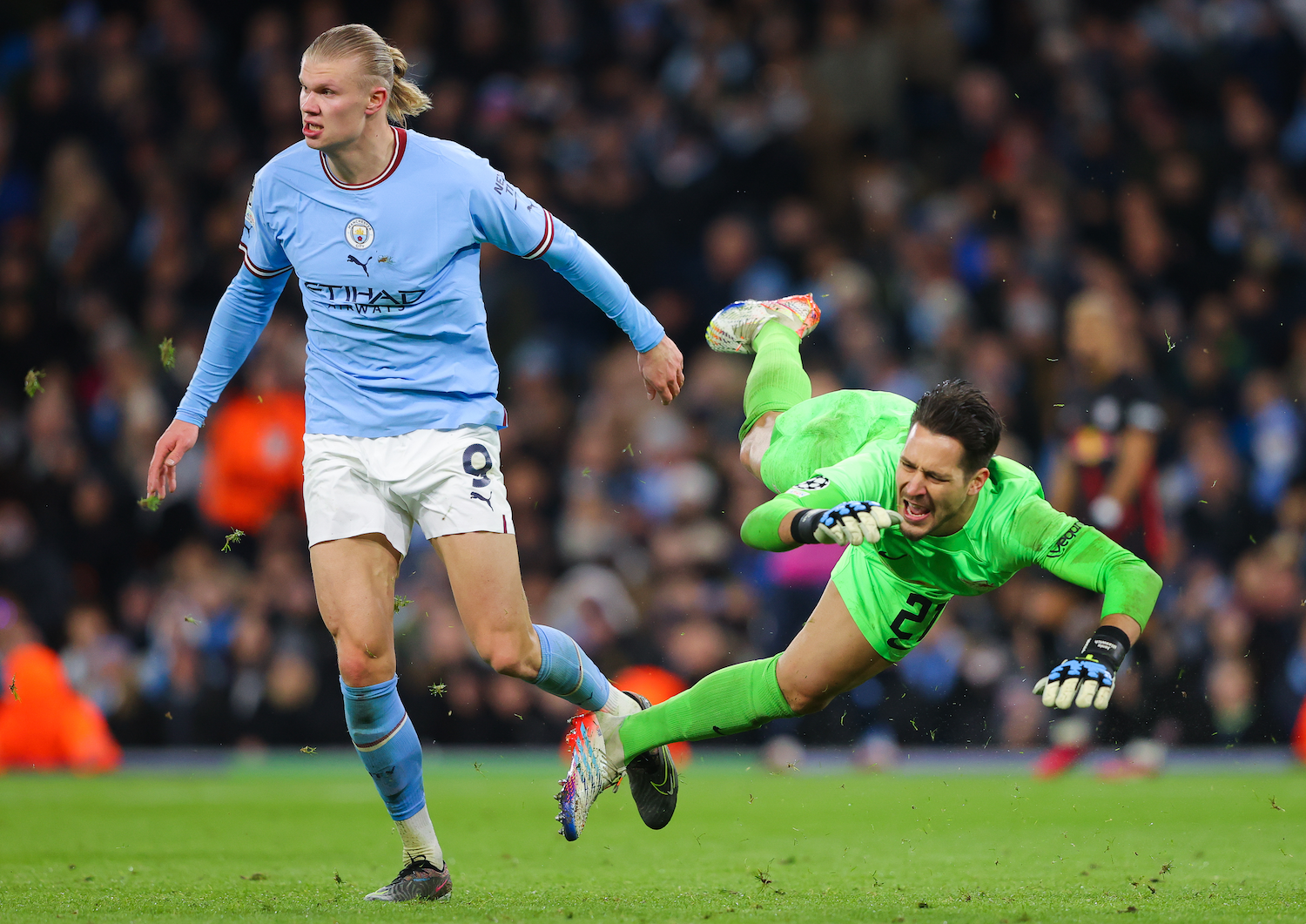 Erling Haaland of Manchester City next to a desperately diving Janis Blaswich of RB Leipzig in Champions League round-of-16