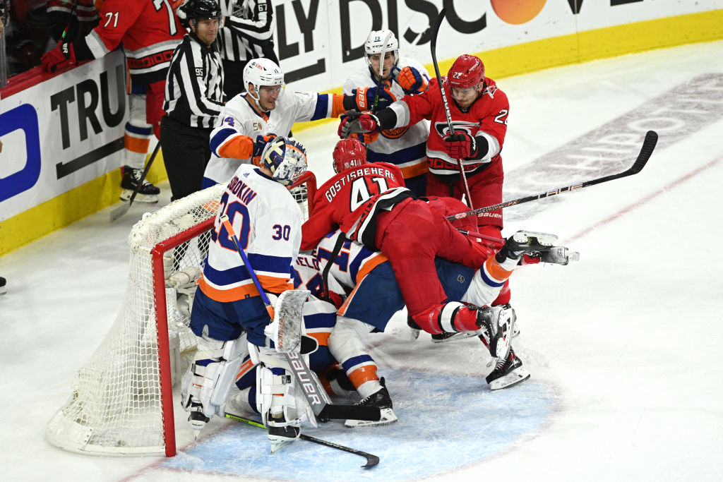 Shayne Gostisbehere leaps onto the back of an Islanders player