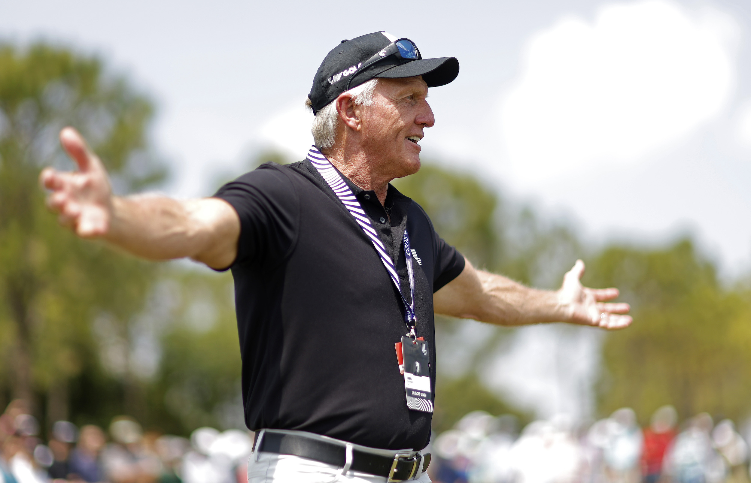 Greg Norman spreads his arms wide for some reason.