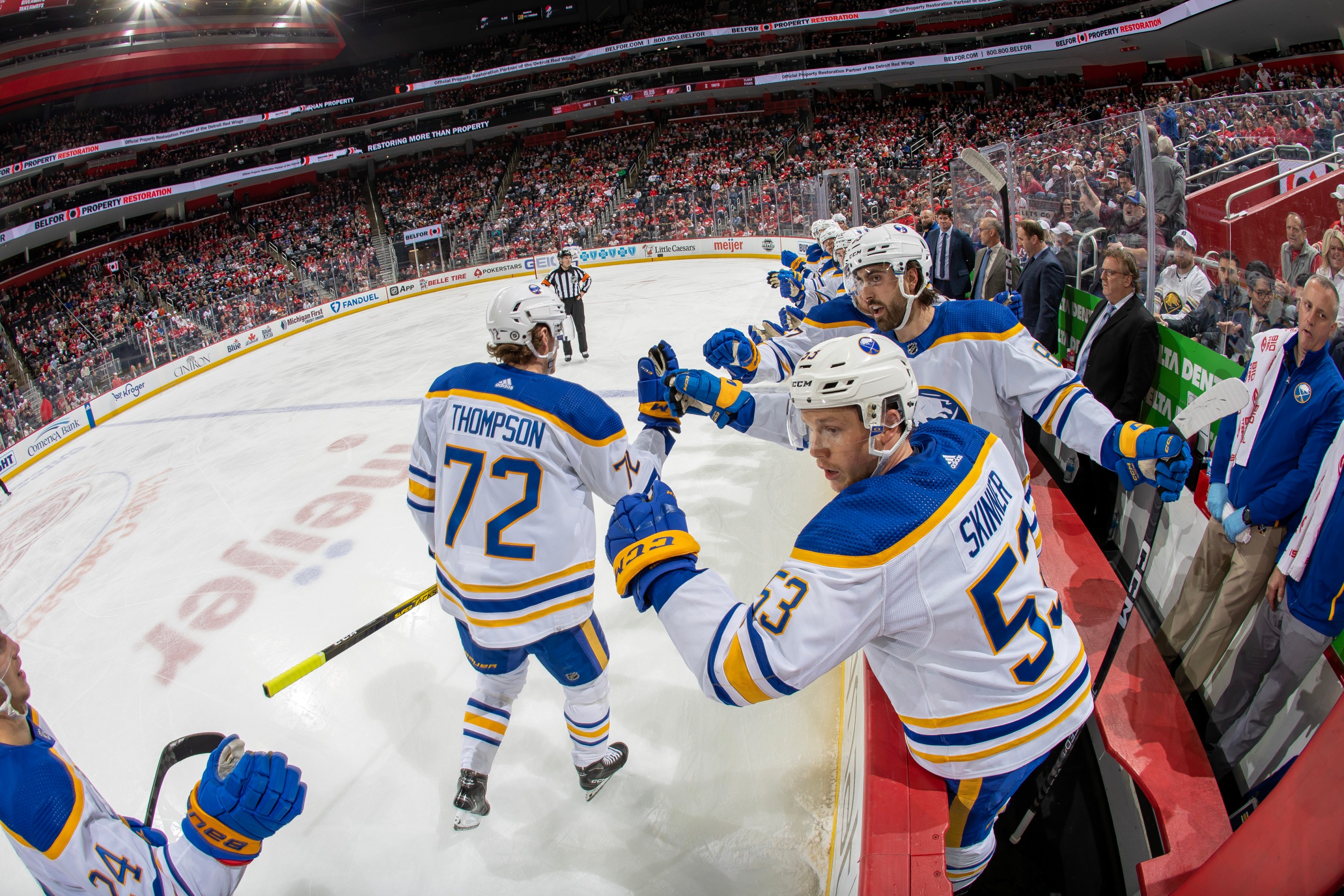 Tage Thompson pounds gloves with his teammates on the bench